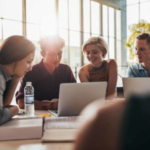 group of young adults looking at laptop screen